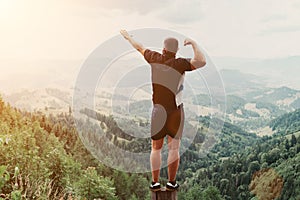 Man standing on of stump in summer mountains