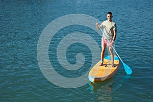 Man standing on the supboard in ocean.
