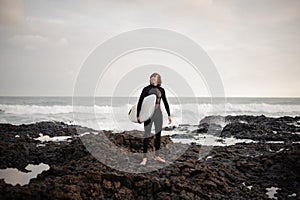 Man standing with a surf in his hands on the beach