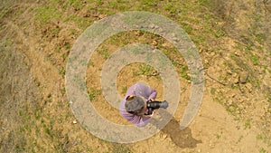 A man is standing and taking pictures. Shooting from the air.