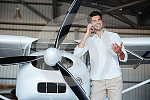 Man standing and talking on mobile phone near the plane