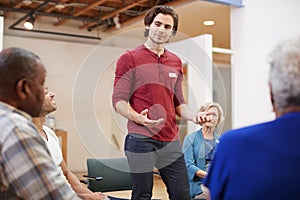 Man Standing To Address Self Help Therapy Group Meeting In Community Center