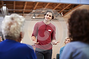 Man Standing To Address Self Help Therapy Group Meeting In Community Center