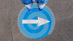 Man standing on the turn right traffic road sign symbol with white arrow pointing right