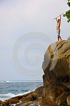 Man standing victoriously on a cliff