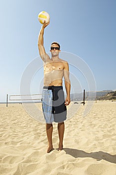 Man Standing With A Volleyball On Beach