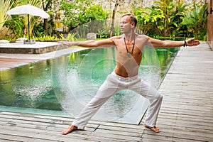 Man standing in warrior yoga pose