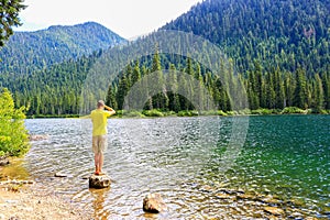 Man standing in water with feet and lokking at mountain