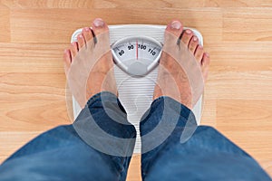 Man Standing On Weighing Scale