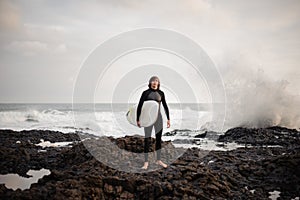 Man standing with a white surf in his hands on the beach