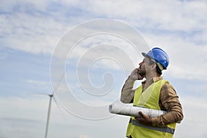 Man standing on wind turbine field