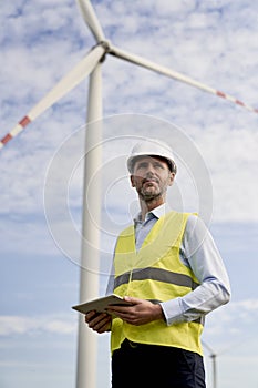 Man standing on wind turbine field