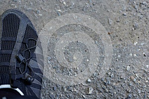 A man stands on the asphalt photo of his feet in shoes with shadows close up