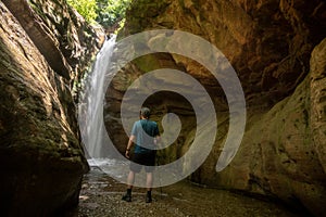 Man Stands at Base of Bear Trap Falls at End of Slot Canyon