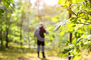 A man stands in a clearing in the forest and tries to find a landmark of the area. Get lost in the forest. Survival in the wild.