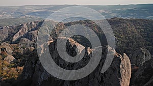 Man stands on the edge of mountain and tries to knock the drone flying over him by stick