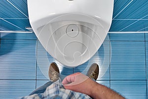 Man stands in front of toilet in toilet and tries to urinate. First-person view. Urinary problem and male disease photo