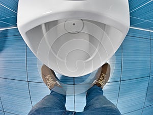 Man stands in front of toilet in toilet and tries to urinate. First-person view. Urinary problem and male disease photo