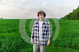 A man stands on green grass in a field