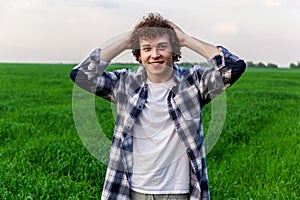 A man stands on green grass in a field
