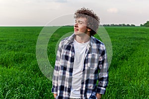 A man stands on green grass in a field