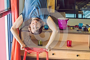 A man stands on his hands upside down in the kitchen