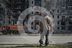 A man stands near a destroyed house that was hit by a shell from military operations in Ukraine