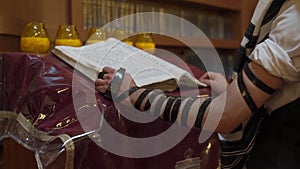 A man stands near the presidium and reads a book. A Jew prays in the synagogue.