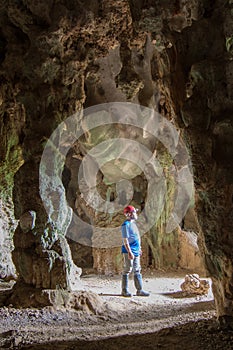 Man stands in Santo TomÃÂ¡s Cave, visible from shaft of light fro