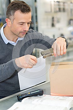 man stapling paper in office