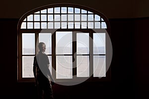 Man staring out a dirty window