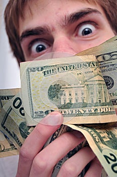 Man staring at a wad of cash