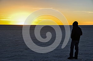 Man starring at the sunset in Salar de Uyuni, Bolivia