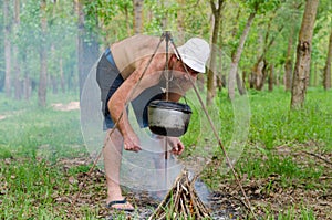 Man starting a cooking fire in a campsite