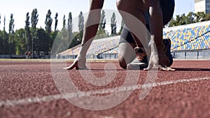 Man in starting position on track, professional runner training at stadium