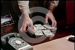 Man stashing stacks of money in briefcase