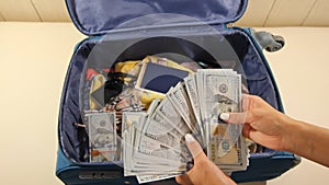 Man stashing stacks of money in briefcase