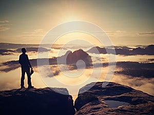 Man stay with red cap on rocky peak. Man walking over rocky summit