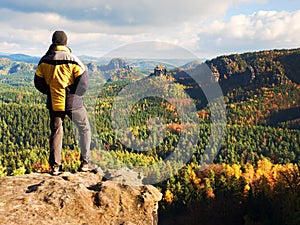 Man stay on sharp rock peak. Satisfy hiker enjoy view. Tall man on rocky cliff watching down