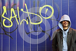 Man is staying near wall with graffiti in a street