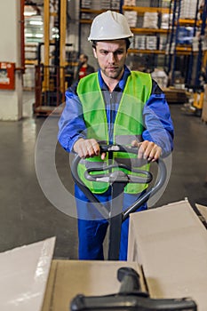 Man steering pallet truck in warehouse
