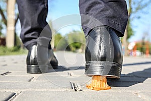 Man stepping in chewing gum on sidewalk