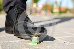 Man stepping in chewing gum on sidewalk
