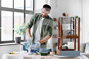 man stirring can with grey color paint at home