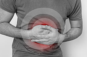 Man with stomach pain is holding his aching belly