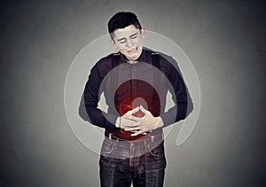 Man with stomach pain indigestion abdomen colored in red photo