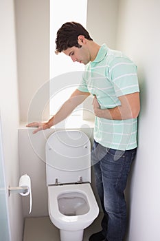 Man with stomach sickness about to vomit into the toilet