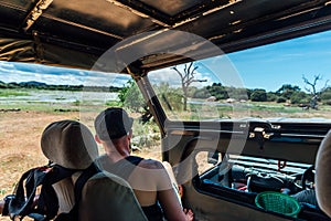 Man stop his car and watch beautiful view in safari