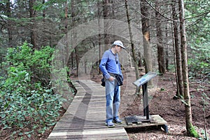 Man Stops to Read the Sign while Hiking