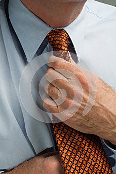 Man straightening necktie